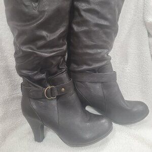 Heeled dress boots go to knee.